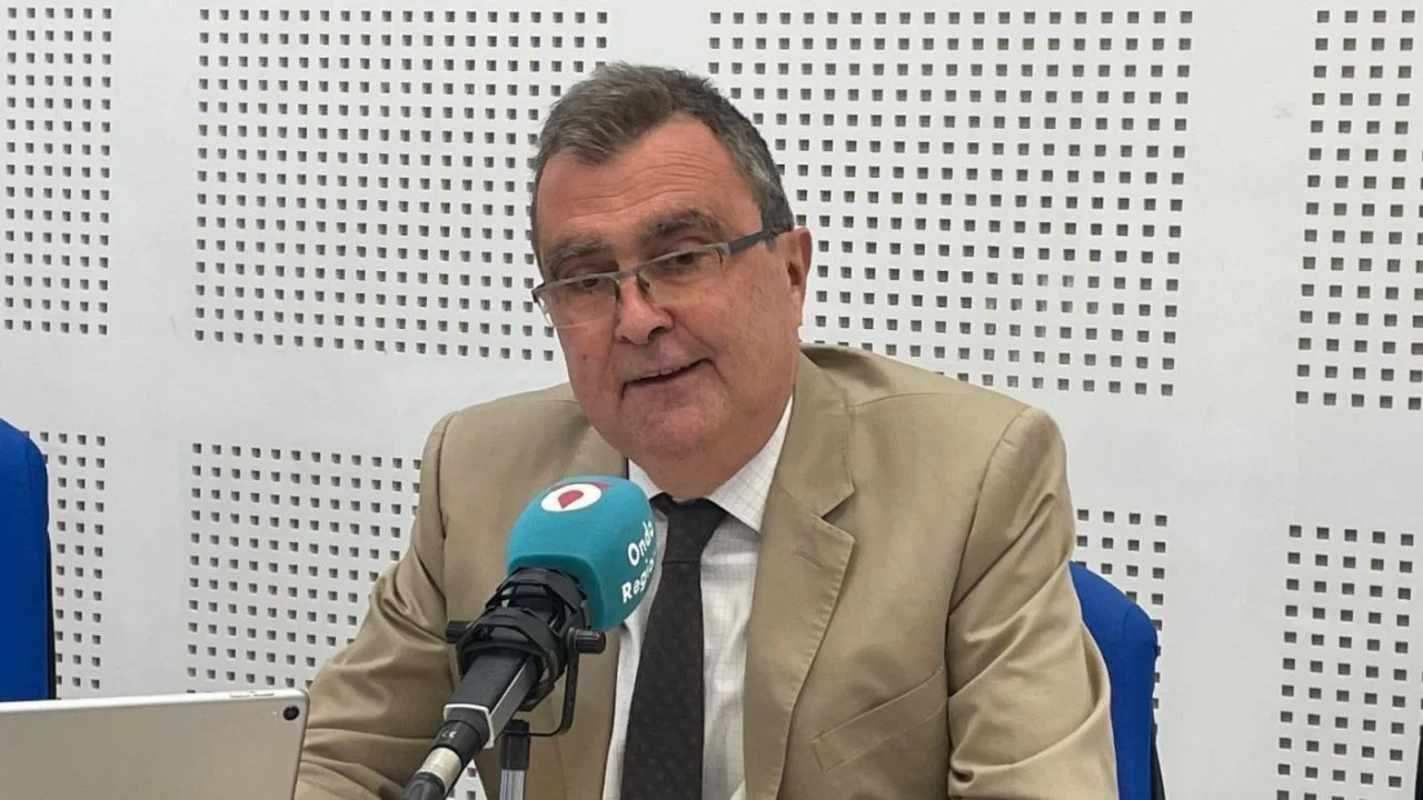 José Ballesta en un estudio de radio, vestido de saco y corbata