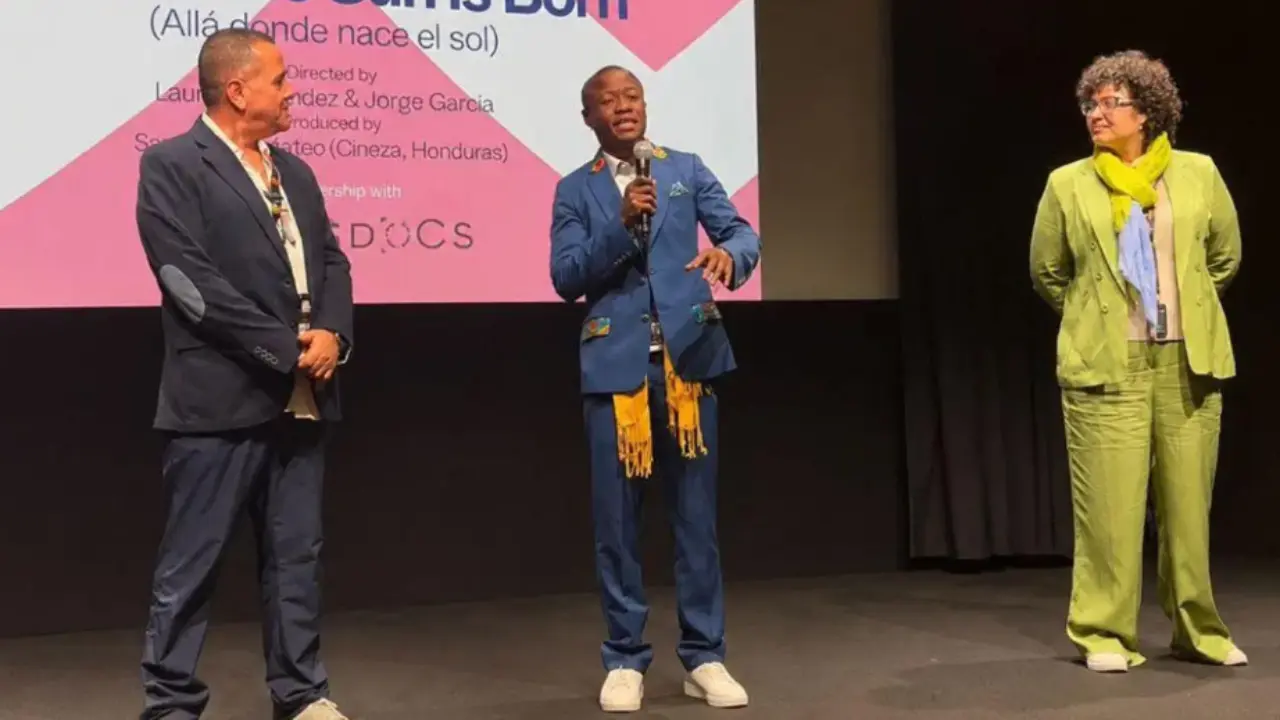 dos hombres y una mujer parados en un escenario