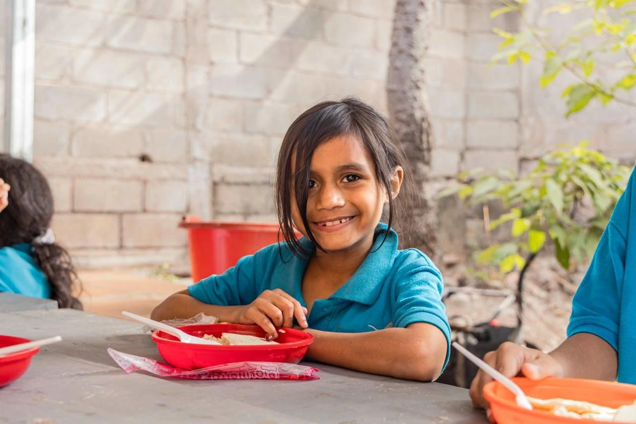 Niña hondureña con su merienda escolar.