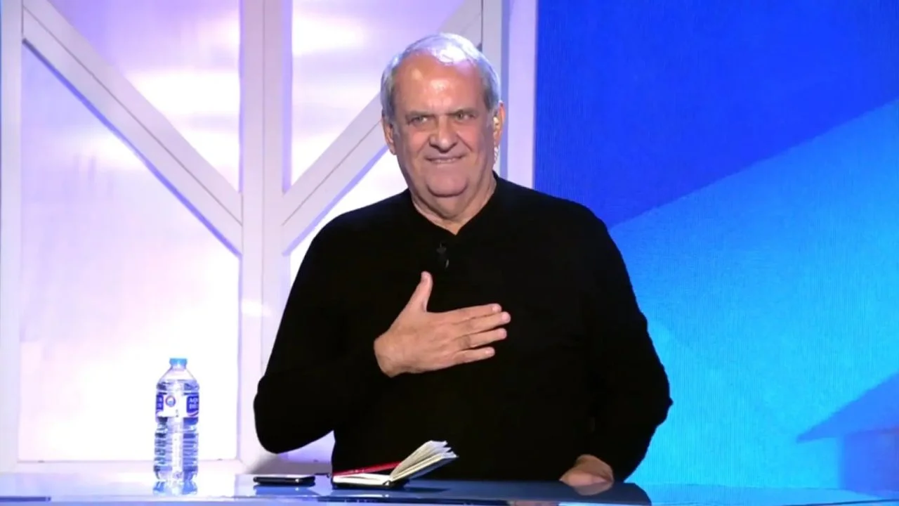 Javier Aroca vestido de negro en un set de televisión.