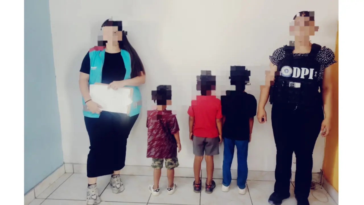 Dos adultos y tres niños parados