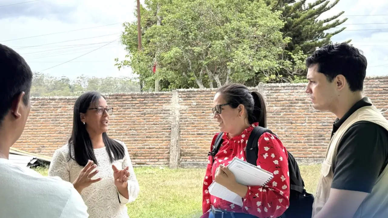 Cuatro personas paradas dialogando