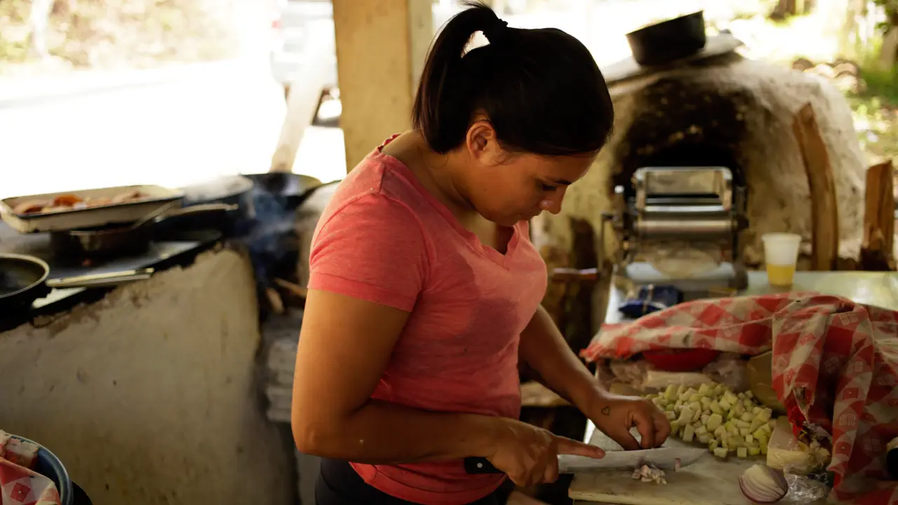 Una mujer prepara alimentos en su vivienda en Valle de Ángeles