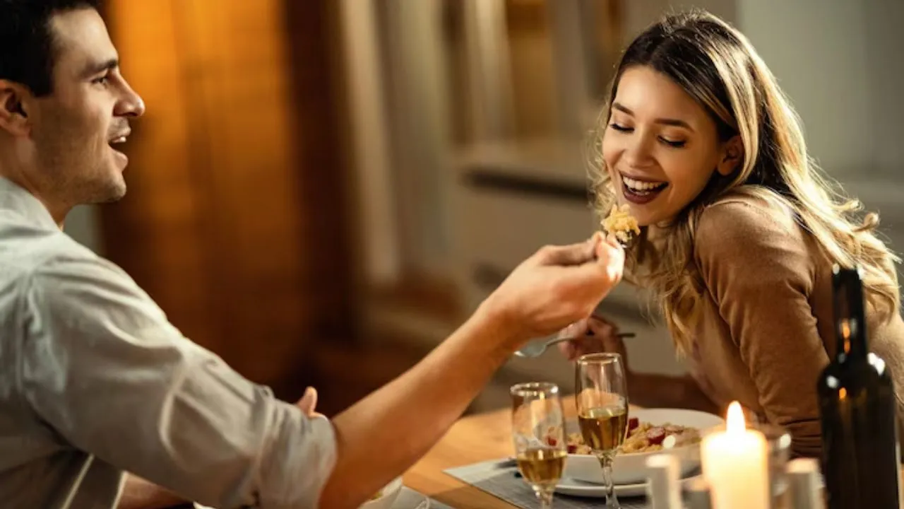 Un caballero le da comida en la boca con un tenedor a una chica que conoció por medio de una aplicación y ahí comenzó su romance.