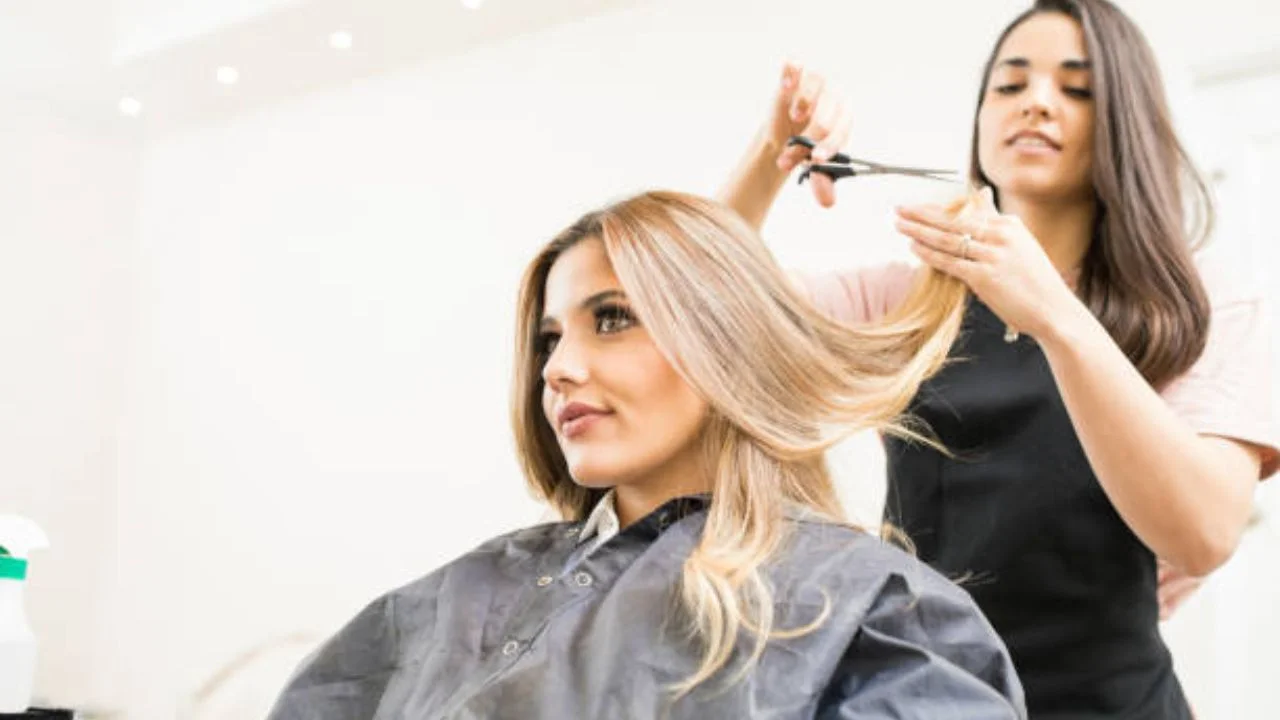 Estilista le corta el cabello a una clienta en un salón de belleza.