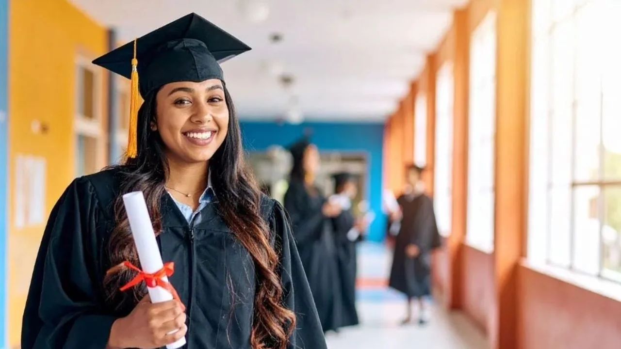 Graduada sonriente sostiene su título.