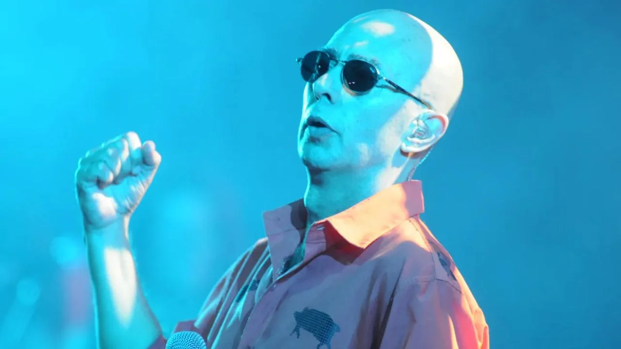 El Indio Solari con lentes en un escenario.