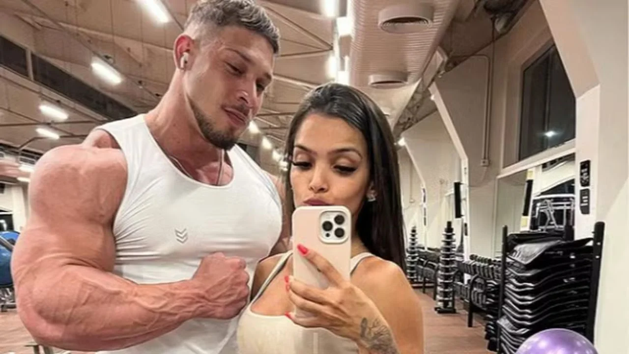 Ramón Dino y su esposa Vitória Viana vestidos de blanco en un gimnasio.