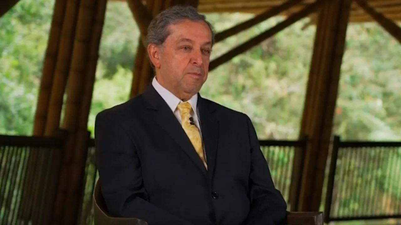 Esteban Jaramillo en una entrevista con un saco negro, camisa blanca y corbata amarilla.
