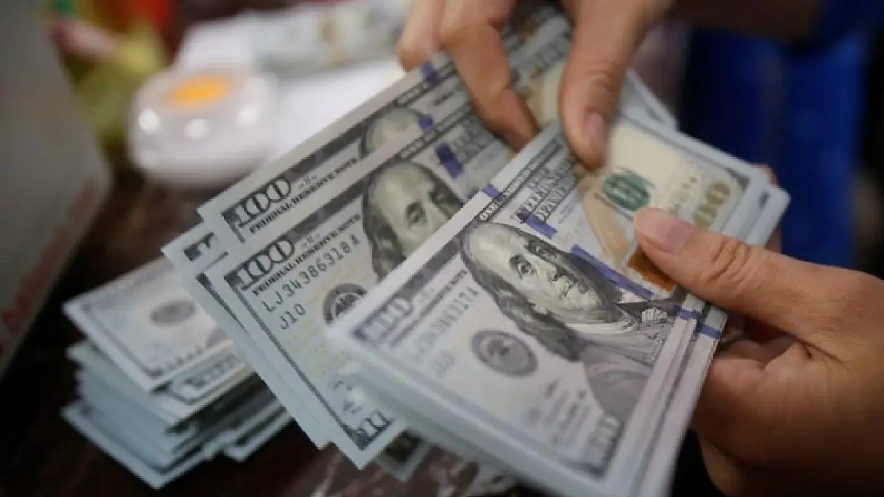 Una persona cuenta billetes de 100 dólares 