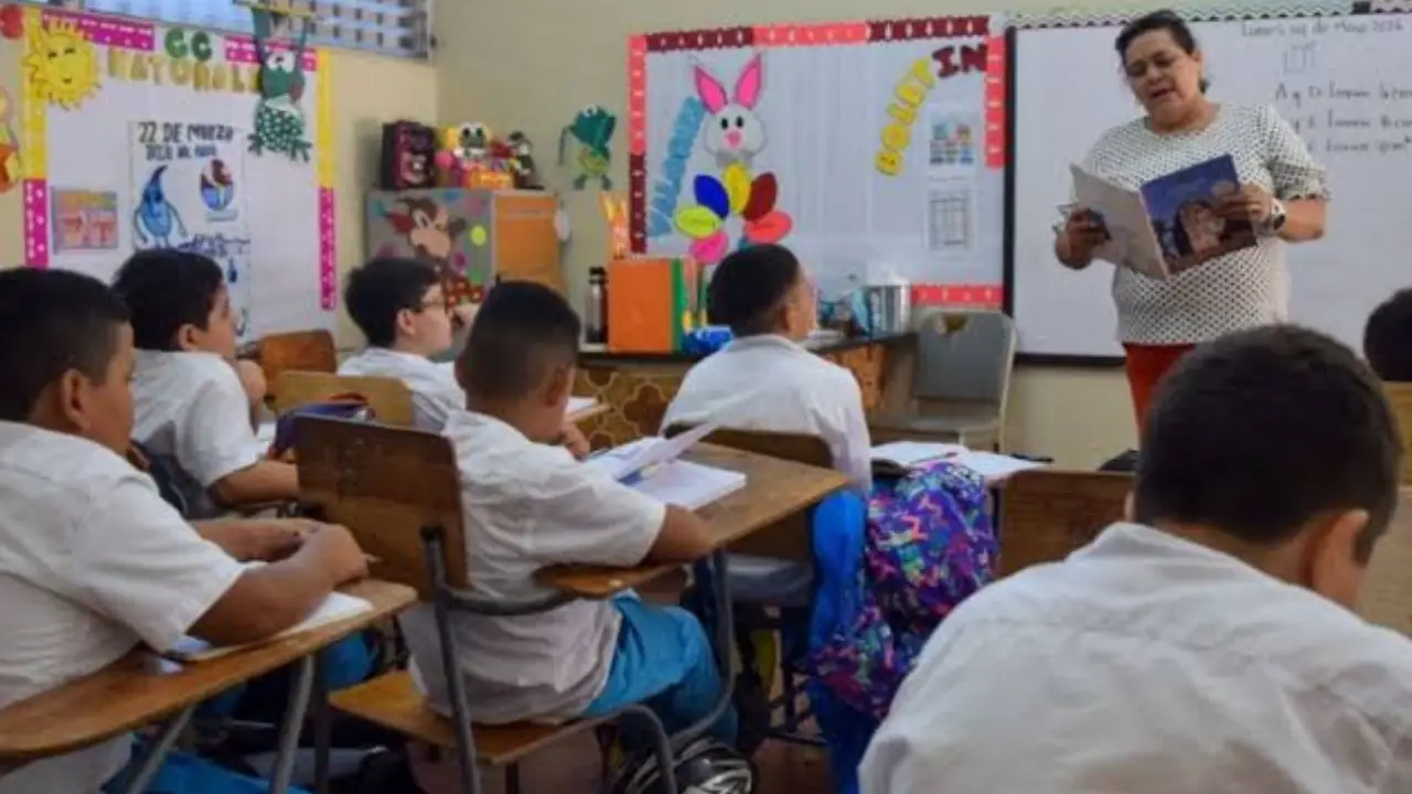 Maestra dando clases en un salón.
