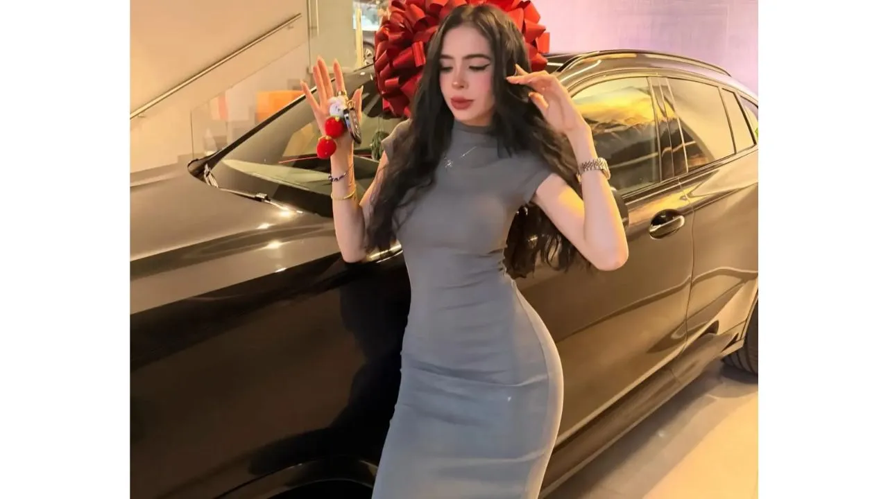 La niña fresa posando a la par de una camioneta.