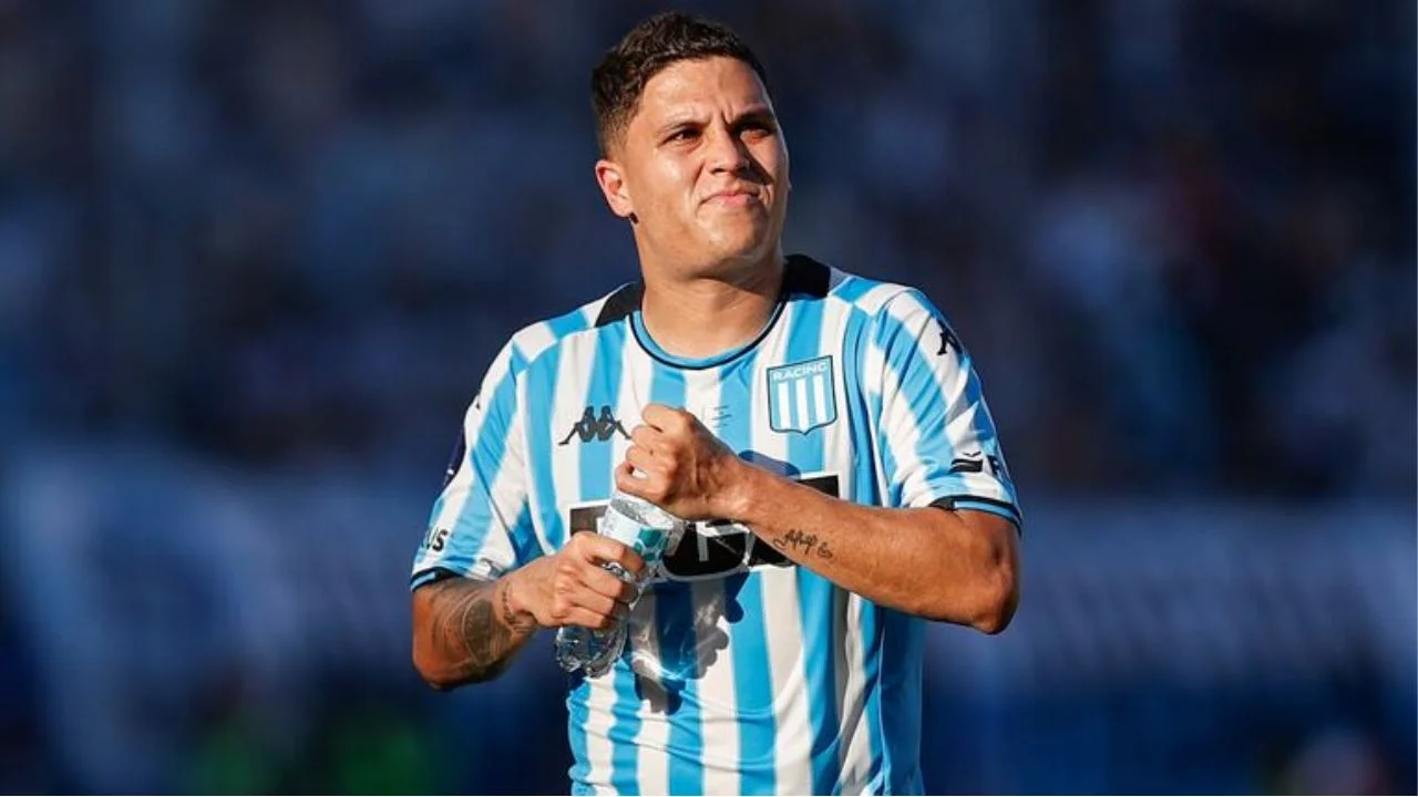 Colombiano con su camisa deportiva bajo sol, destapa un bote con agua.