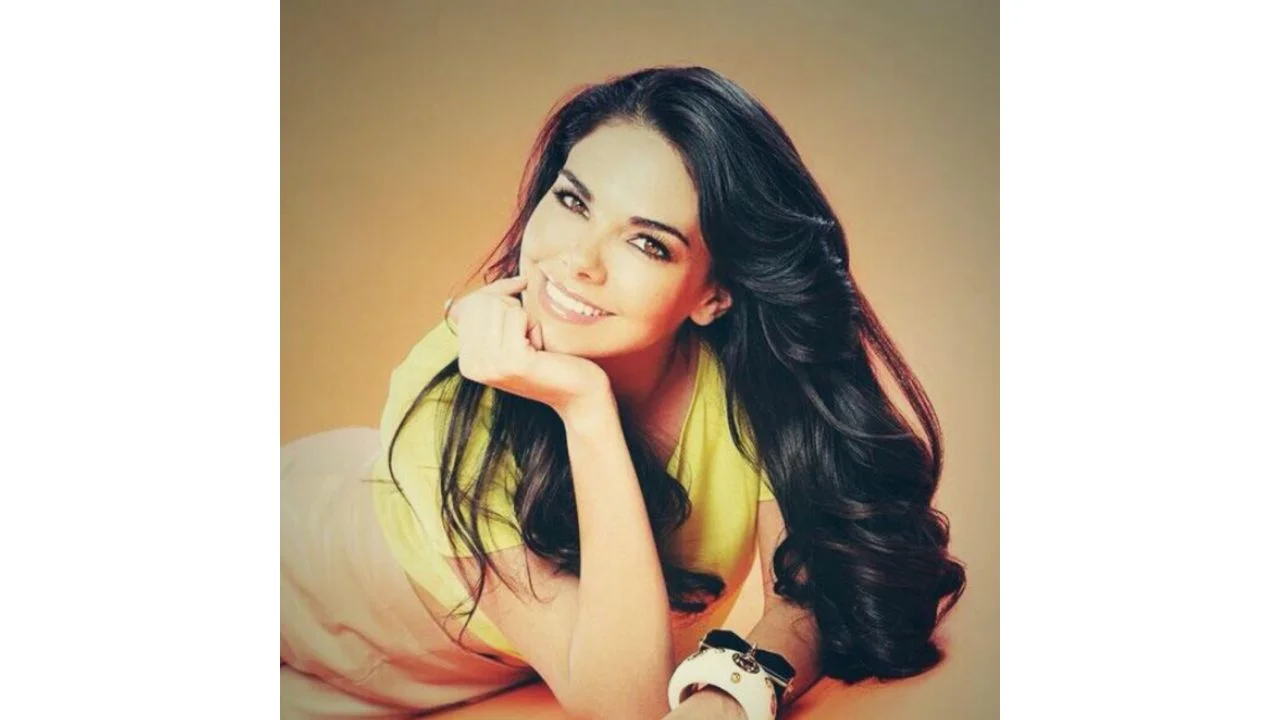 Protagonista de telenovelas acostada con su cabello extendido una prenda de color amarillo.