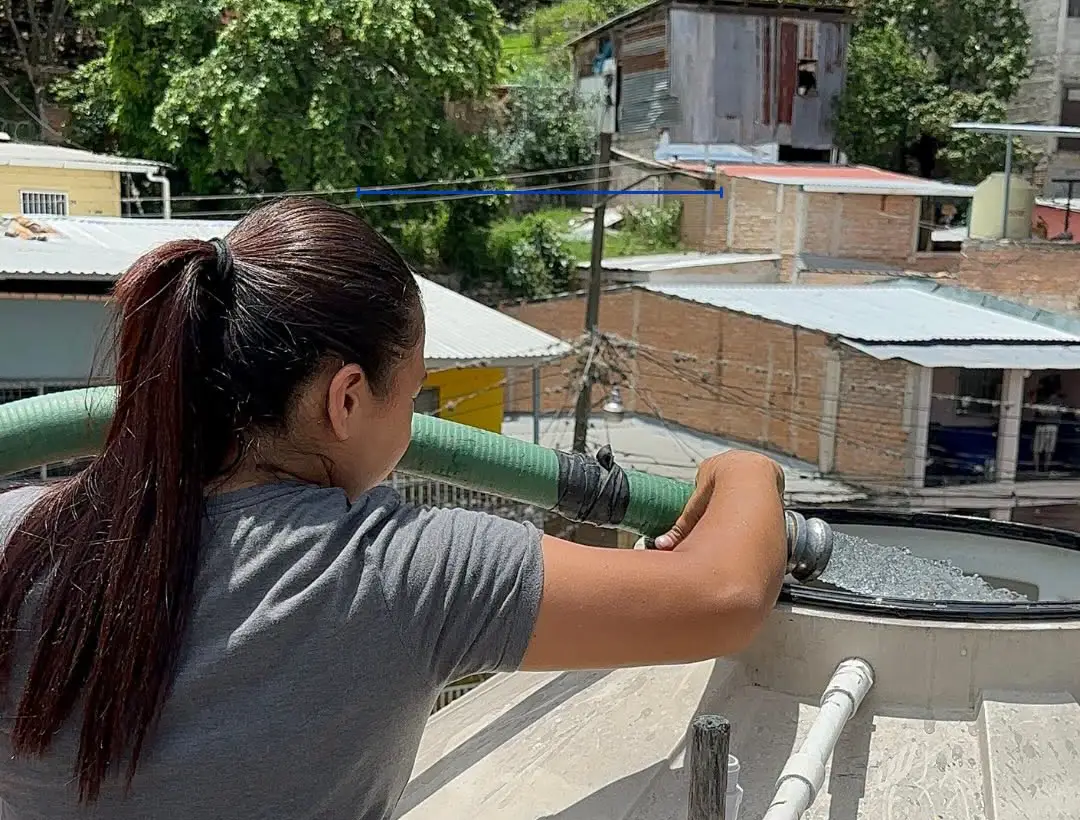 Mujer llena un tanque de agua