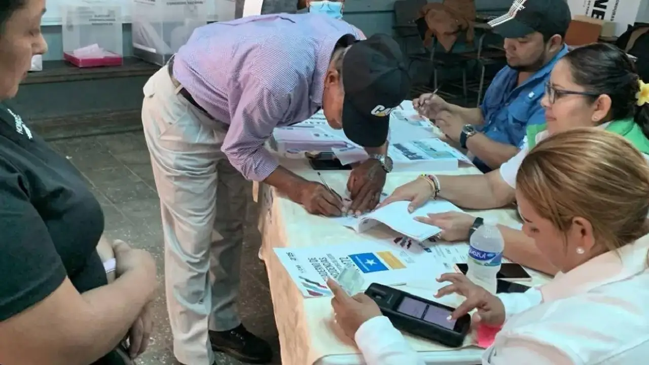Un ciudadano firma el cuadernillo tras ejercer el sufragio en Honduras