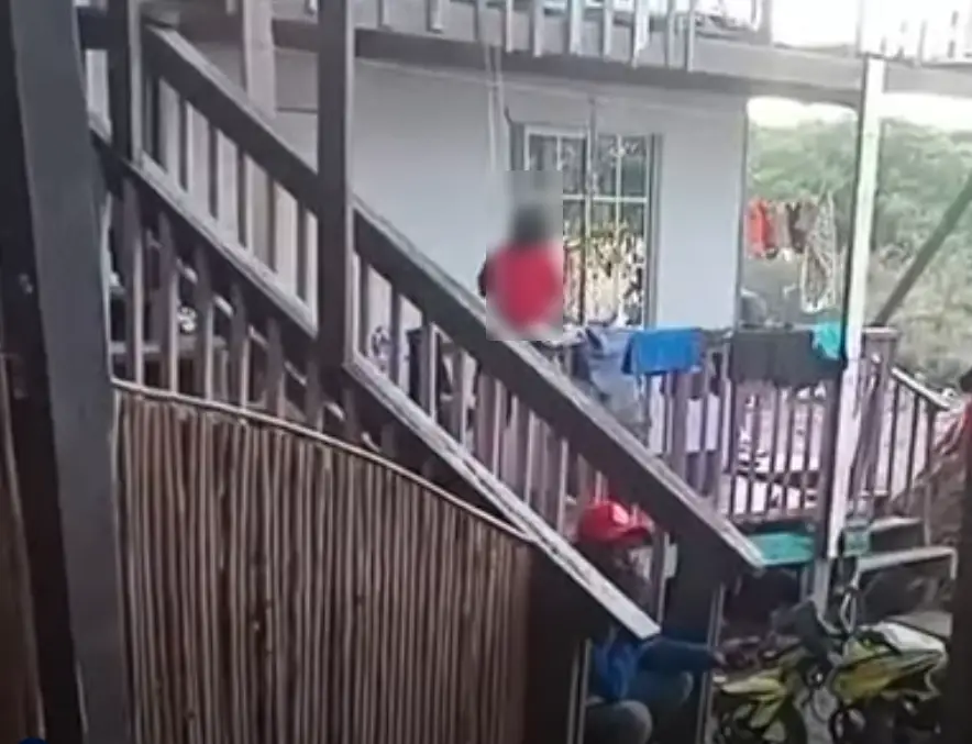 Captura de video muestra a niña sujetada a un lazo colgado de la viga de una casa  