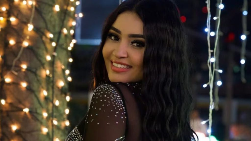 Creadora de contenido con una sonrisa y vestida de color negro.