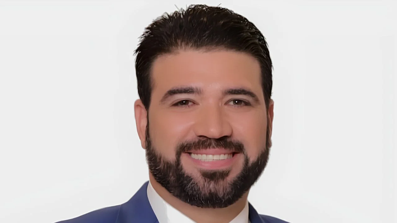 Carlos Mercader vestido de saco y corbata en un fondo blanco.