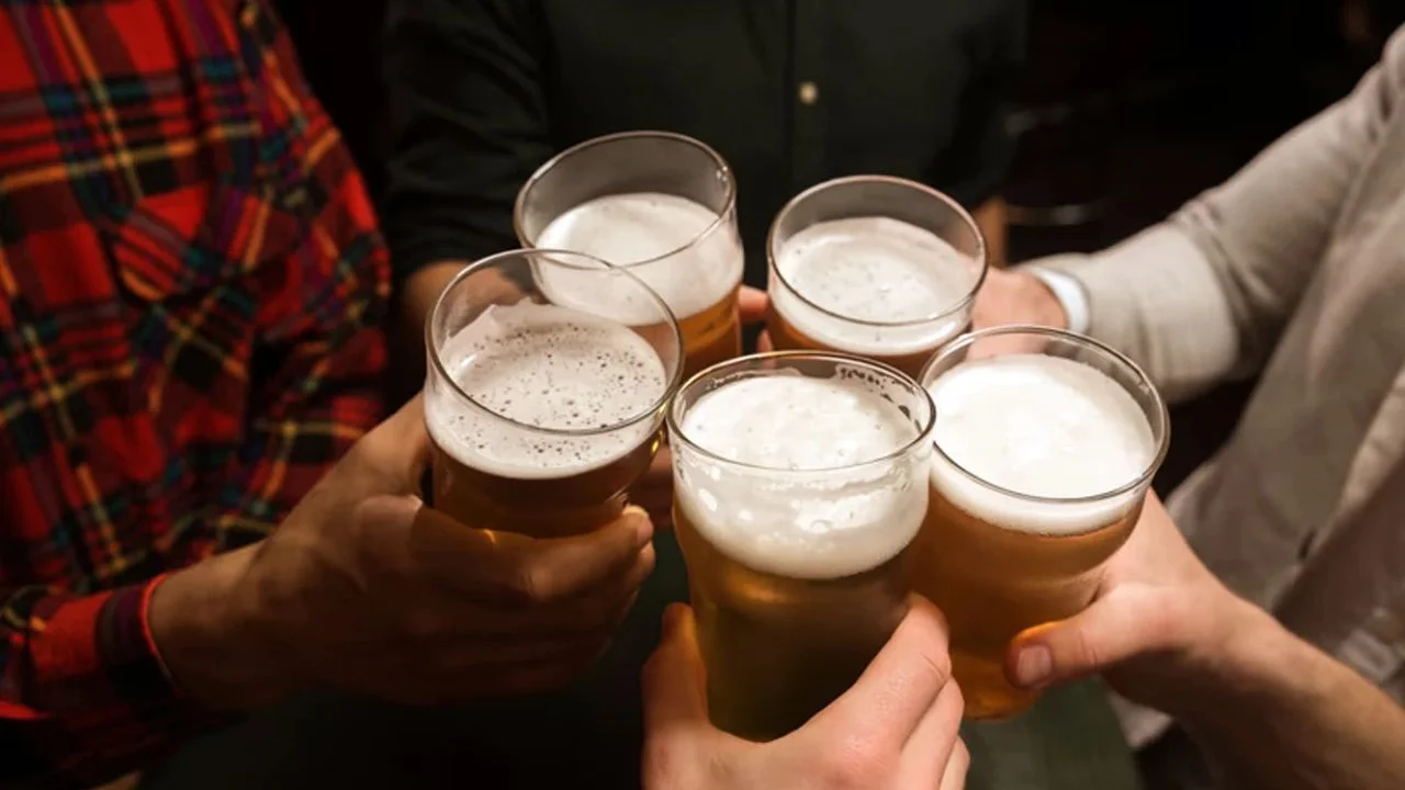 Personas brindando con cerveza.