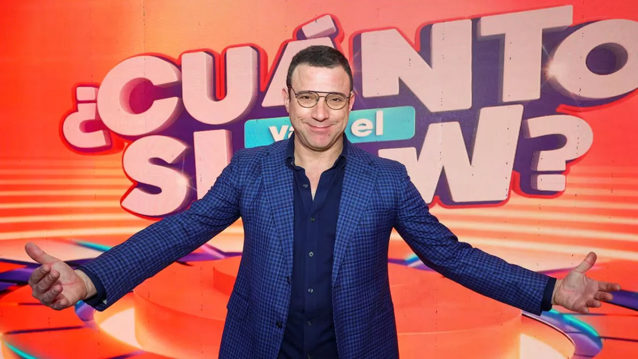 Julián Elfenbein con un blazer azul y una camisa negra de botones.