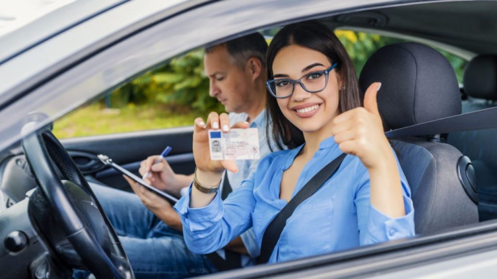 Una mujer presenta su licencia de conducir con una sonrisa reluciente.