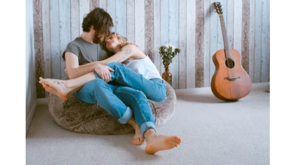 Pareja acostados y a la par tienen una guitarra.