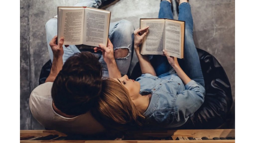 Una pareja acostados leyendo.