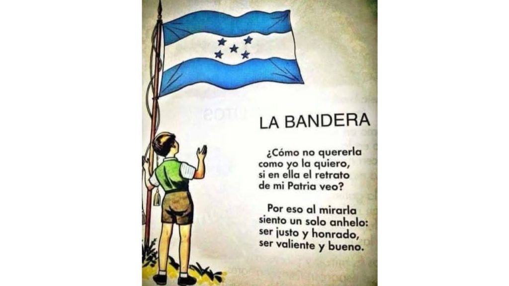 Un niño a la par de una bandera mientras lee una poesía relativa al mes patrio.
