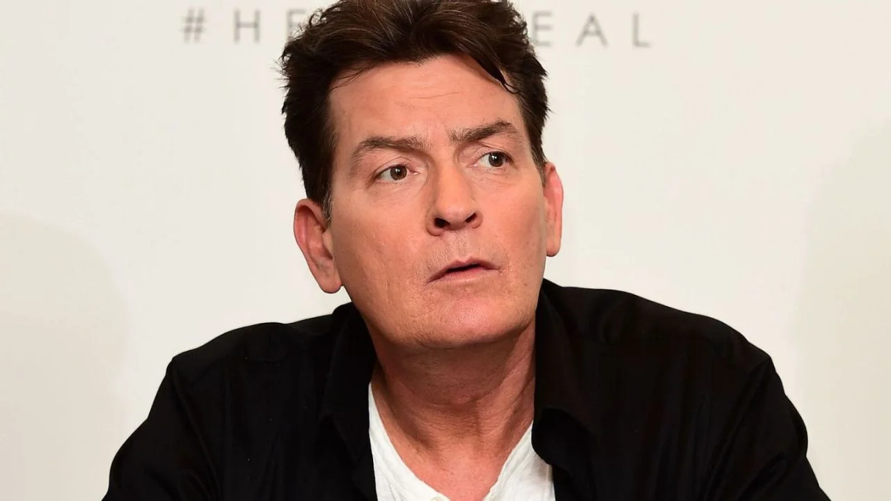Charlie Sheen vestido con una chaqueta negra y una camisa blanca.