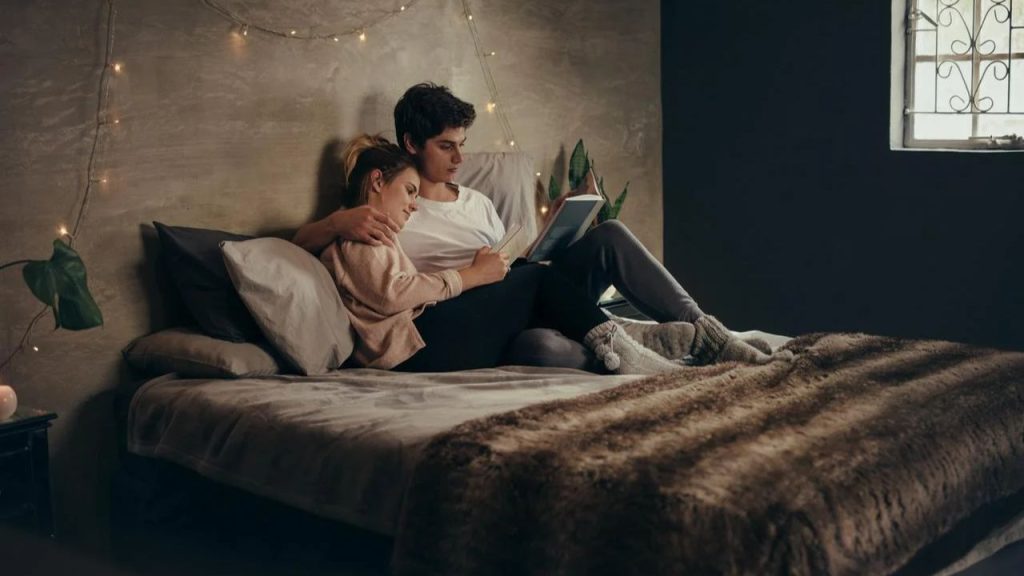 Una pareja sostiene un libro de lectura.
