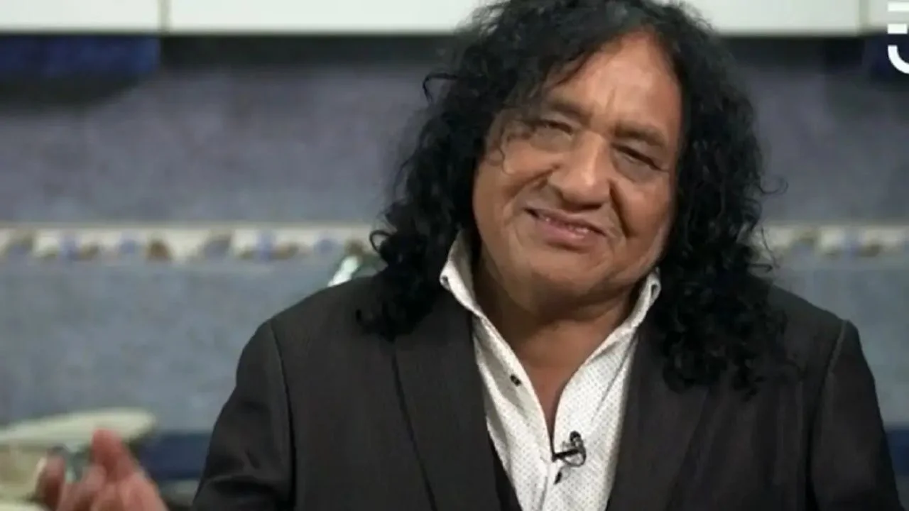 Adrián Chauque vestido con un saco negro y una camisa blanca.