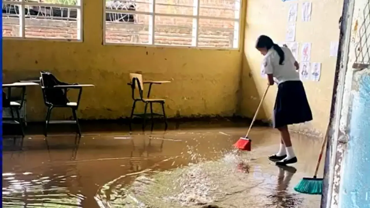 Niños sacan agua de las aulas tras inundación en centro educativo de Choluteca Imagen de Niños sacan agua de las aulas tras inundación en centro educativo de Choluteca