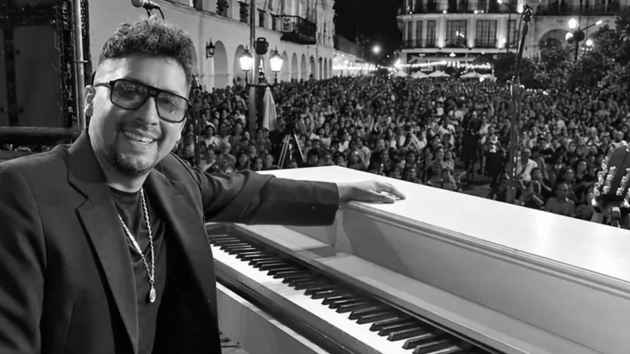 Fotografía en blanco y negro de Lucas Montanaro junto a un piano.