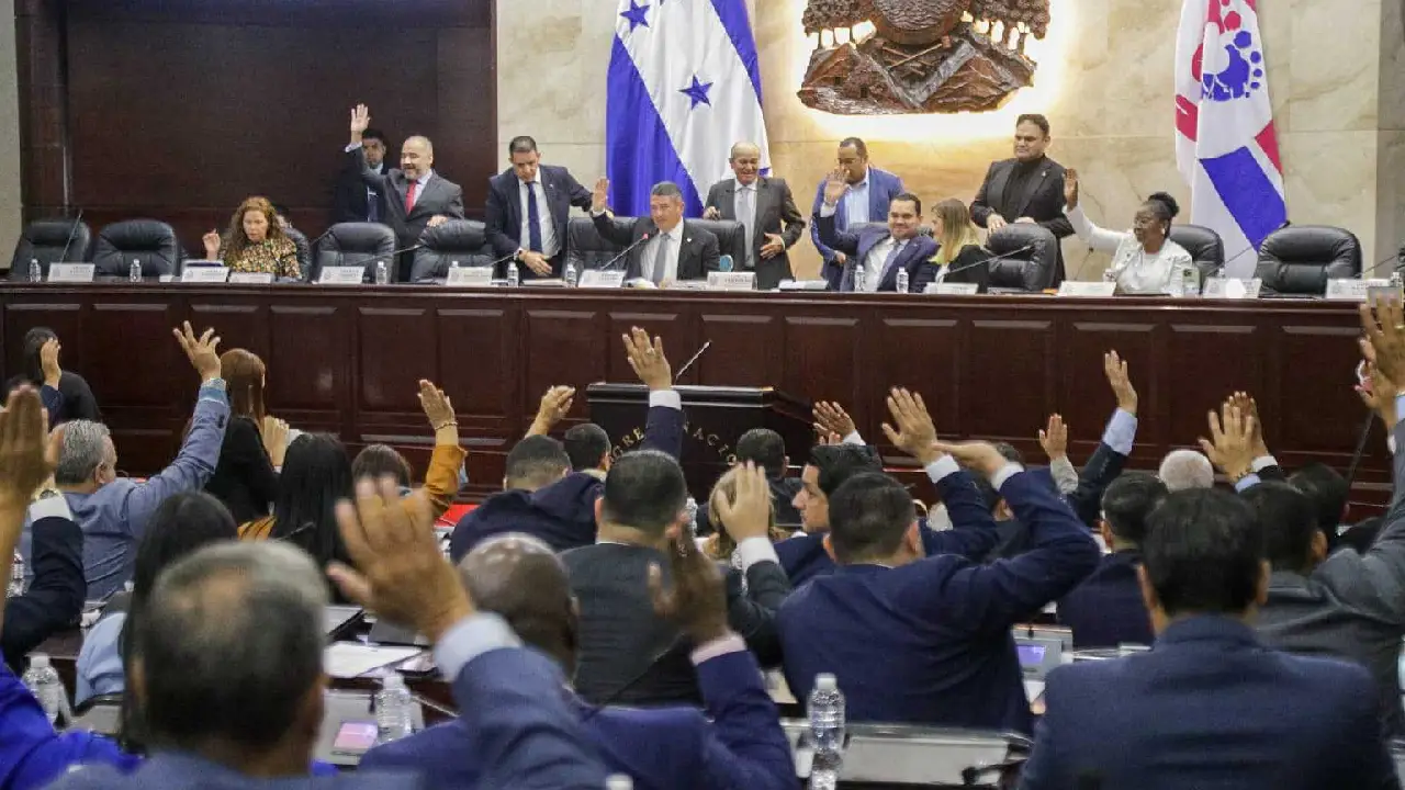 Diputados del Congreso Nacional de Honduras levantan la mano durante una votación en sesión legislativa