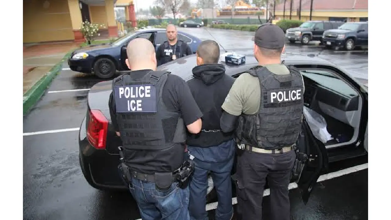 Agentes de ICE con una persona detenida.