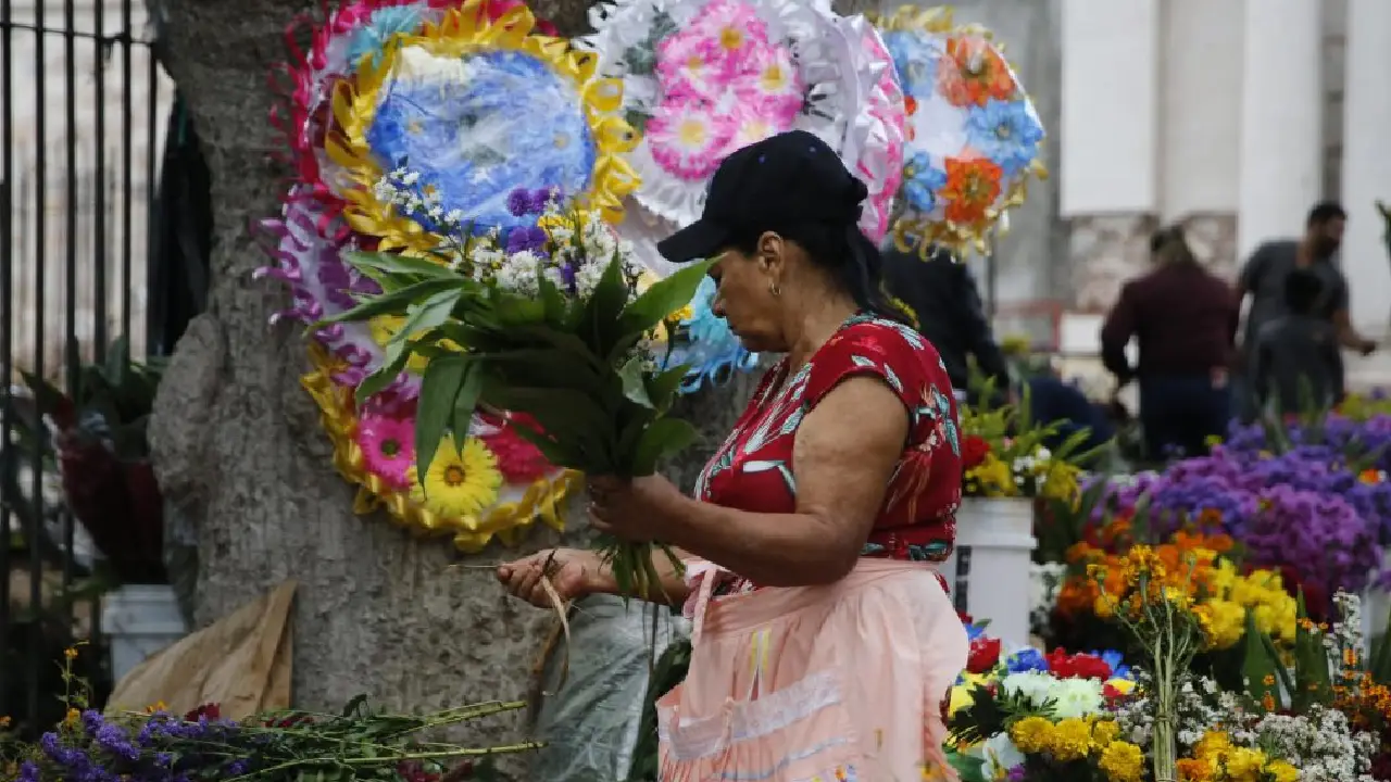 Una hondureña vende flores en la entrada a un cementerio en Honduras