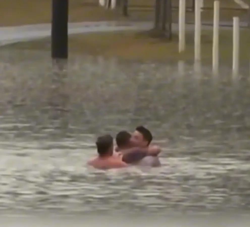 Momento en que el hombre abraza al reportero y al otro que lo pudieron salvar de las inundaciones en Australia